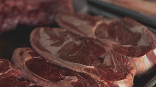 Côtes de bœuf crues présentées en vitrine réfrigérée