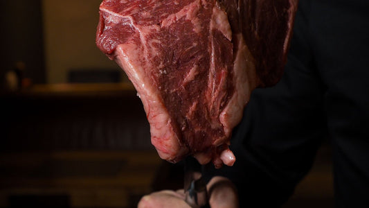 Boucher présentant une grosse pièce de bœuf cru