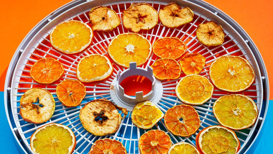 Tranches d'agrumes et de pommes séchées sur plateau de déshydrateur