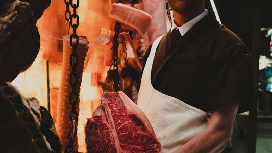 Boucher présentant une pièce de bœuf en boutique