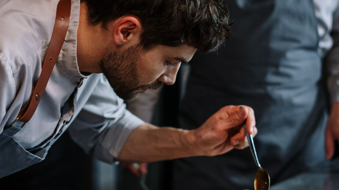 Deux chefs dressant un plat en cuisine industrielle